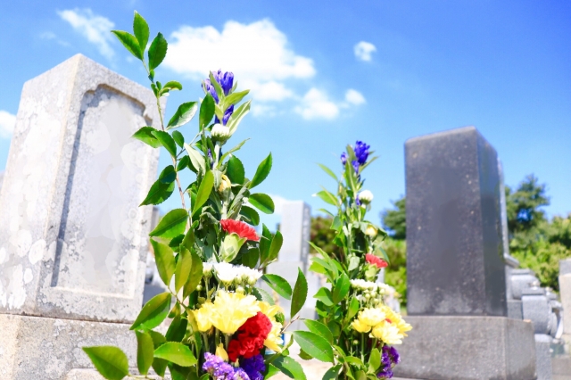 墓地に並ぶ墓石と墓前に生けられた花束