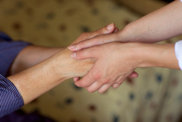 手を握り合う高齢者と現役世代