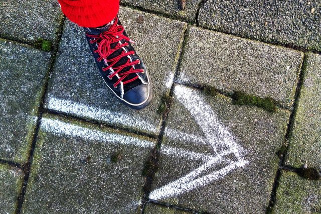 女性の靴と地面に描かれた矢印