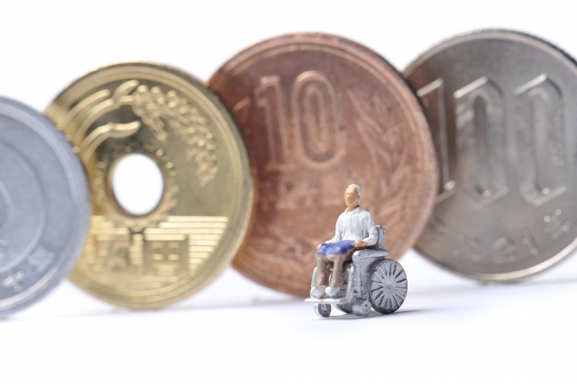 ミニチュア 車椅子の高齢者男性とお金