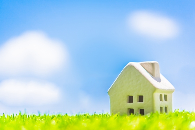 青空と芝生の中の白い住宅模型