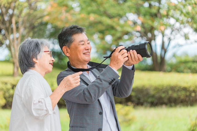 旅行先で一眼レフカメラを使う高齢者夫婦