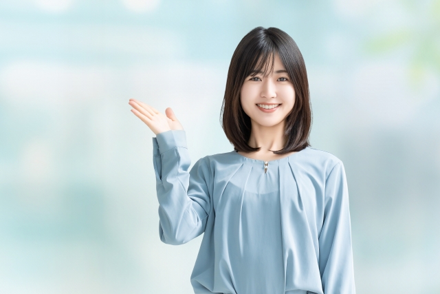 手で案内をする女性