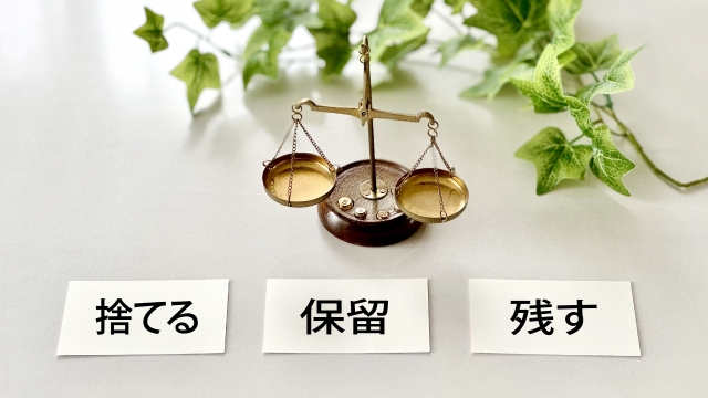 天秤と3枚のカードに捨てる保留残すの文字