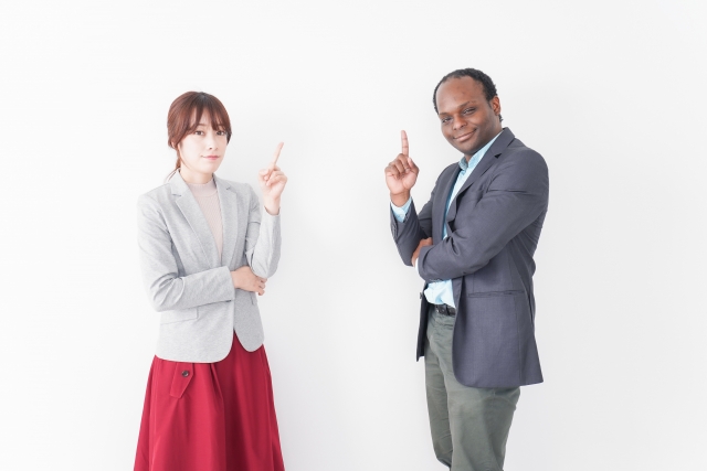 指を上にあげる２人の講師