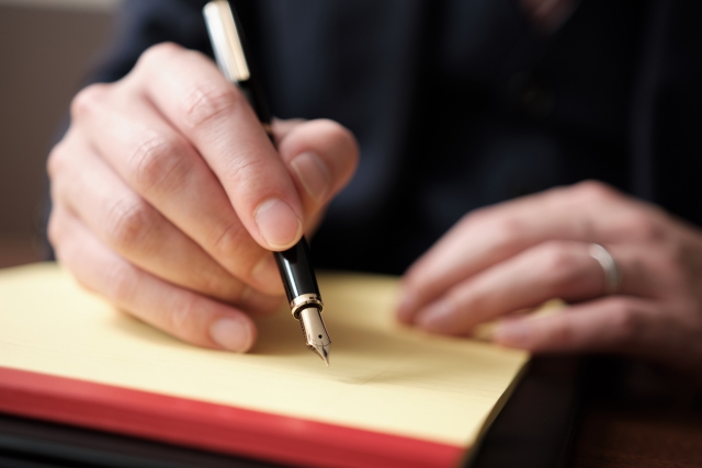 リーガルパットにメモを書く弁護士の手元