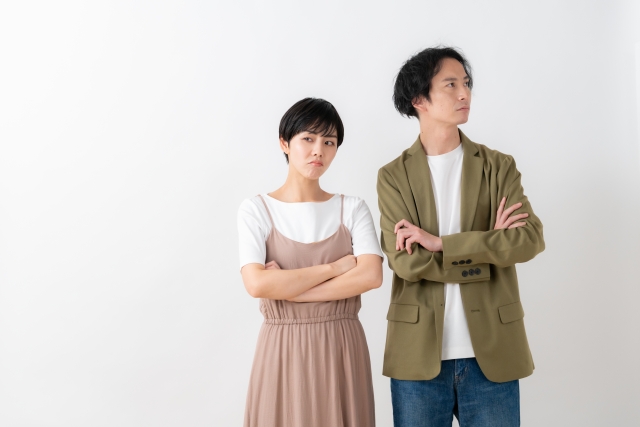 怒り顔で腕を組む男女