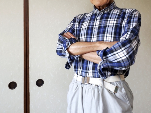 腕組みする高齢男性