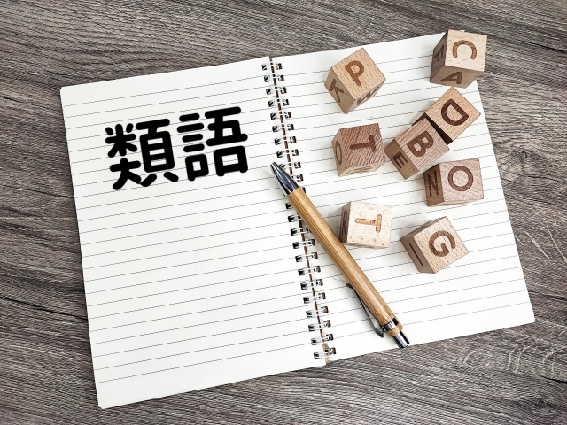 類語と書かれたノートとペンと英字ブロック