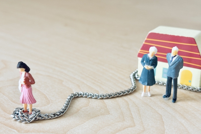 実家の両親に束縛される若い女性の人形