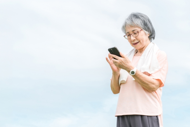 運動途中にスマホを見るシニア女性