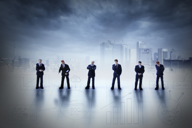不穏な空気の中で並ぶビジネスマン人形