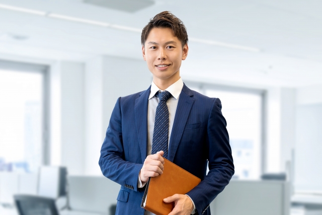バインダーを持つ笑顔の男性ビジネスマン