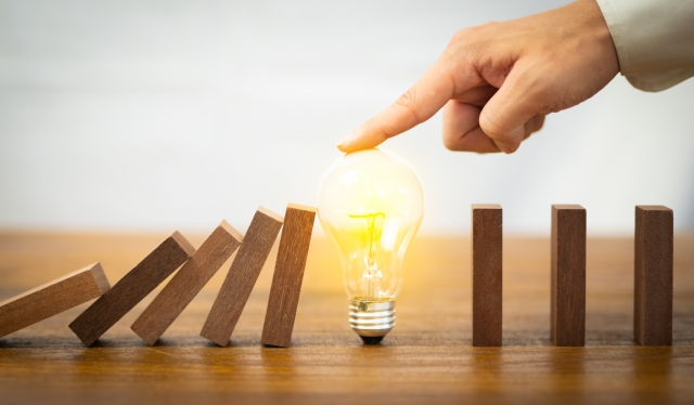 ドミノ倒しを止める電球を押さえる手