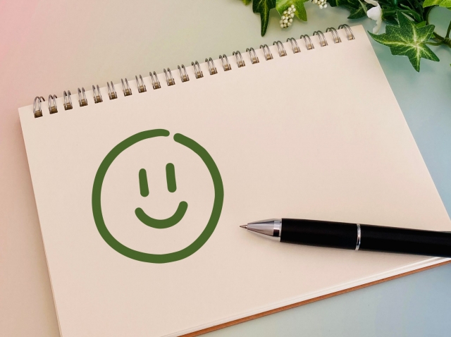 スケッチブックにニコちゃんマークを描く