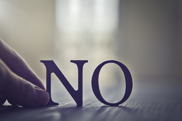 NOの文字をそっと置く手