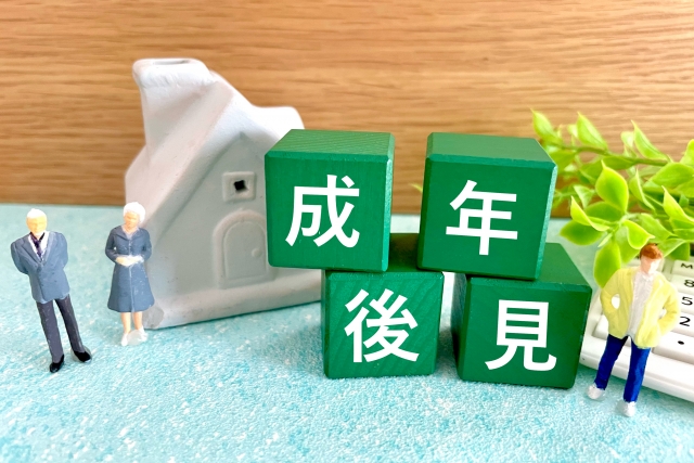 成年後見と書かれたブロックと家・高齢者・子供のミニチュア