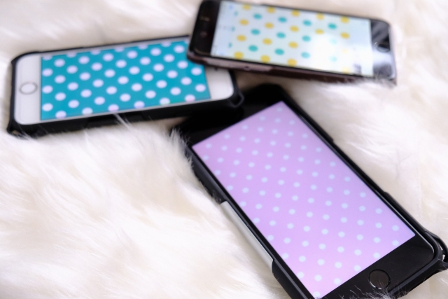 毛皮の上に置かれた３台のスマホ