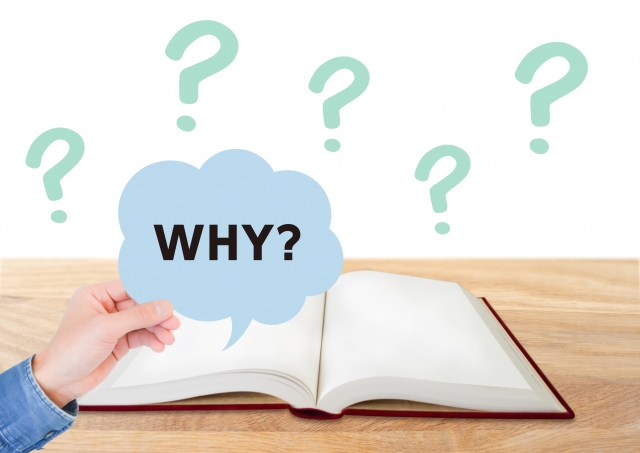 WHY？と書かれた吹き出しを持つ手と開かれた本