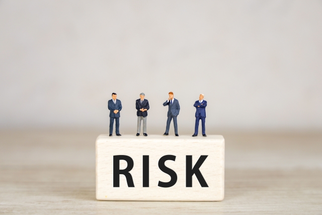 RISKと書いた箱の上に乗る男性の人形