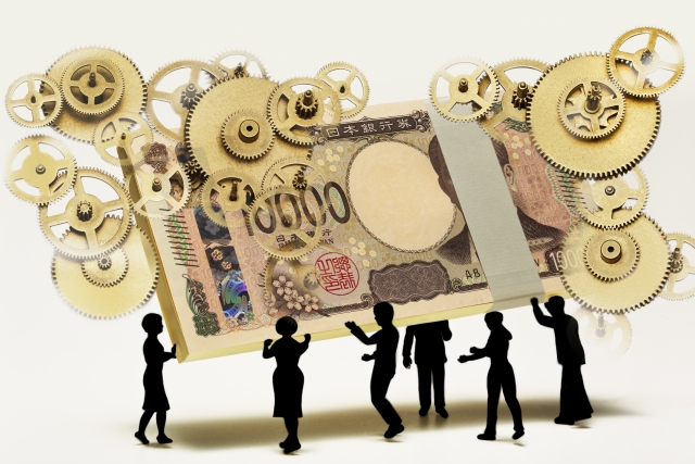 新札の1万円の束を持ち上げる6人の人